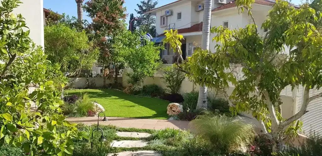 גינה פרטית עם דשא, עצי פרי ושביל אבנים